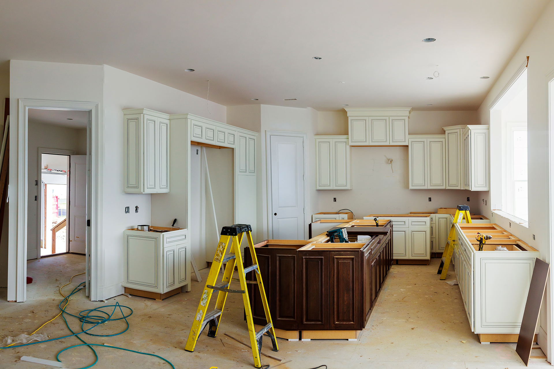 Remodeled white kitchen with large island and pendant lights