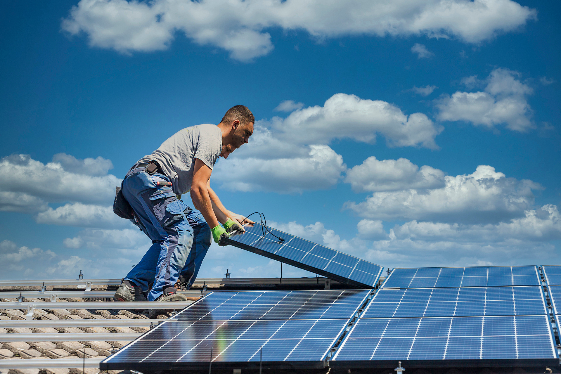 Technician installing solar panel wiring and inverter unit